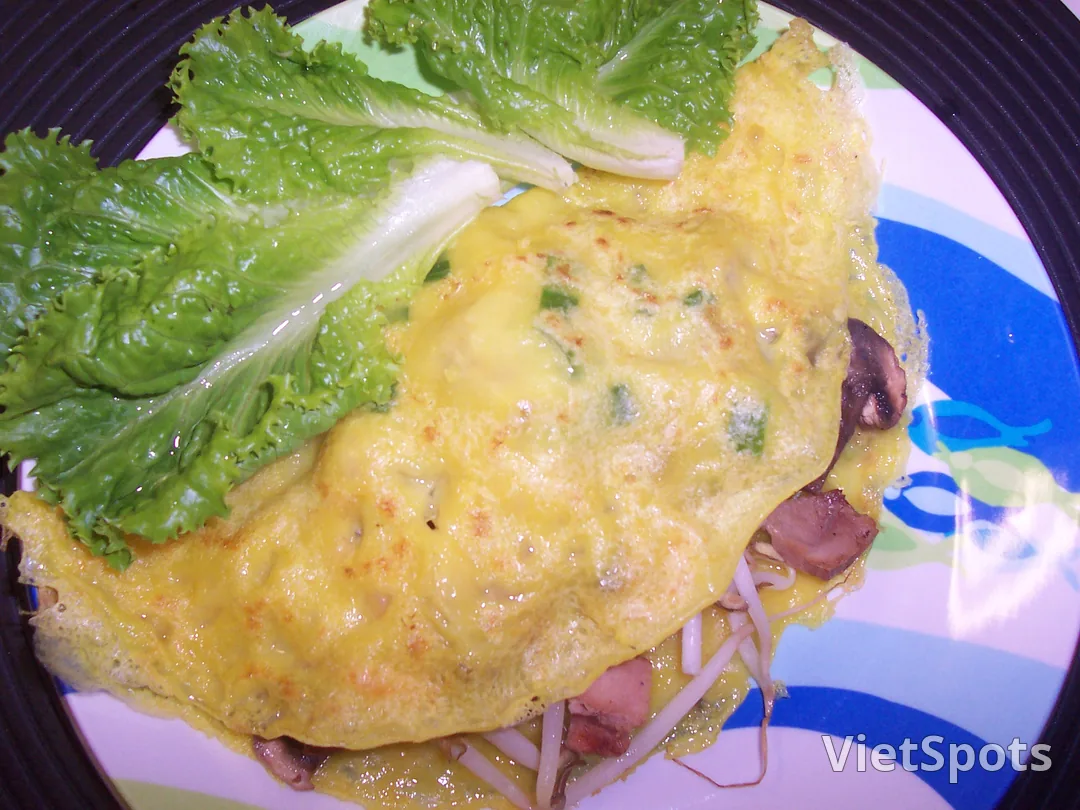Bánh xèo — vỏ vàng nghệ giòn, nhân giá đỗ và thịt, kèm xà lách