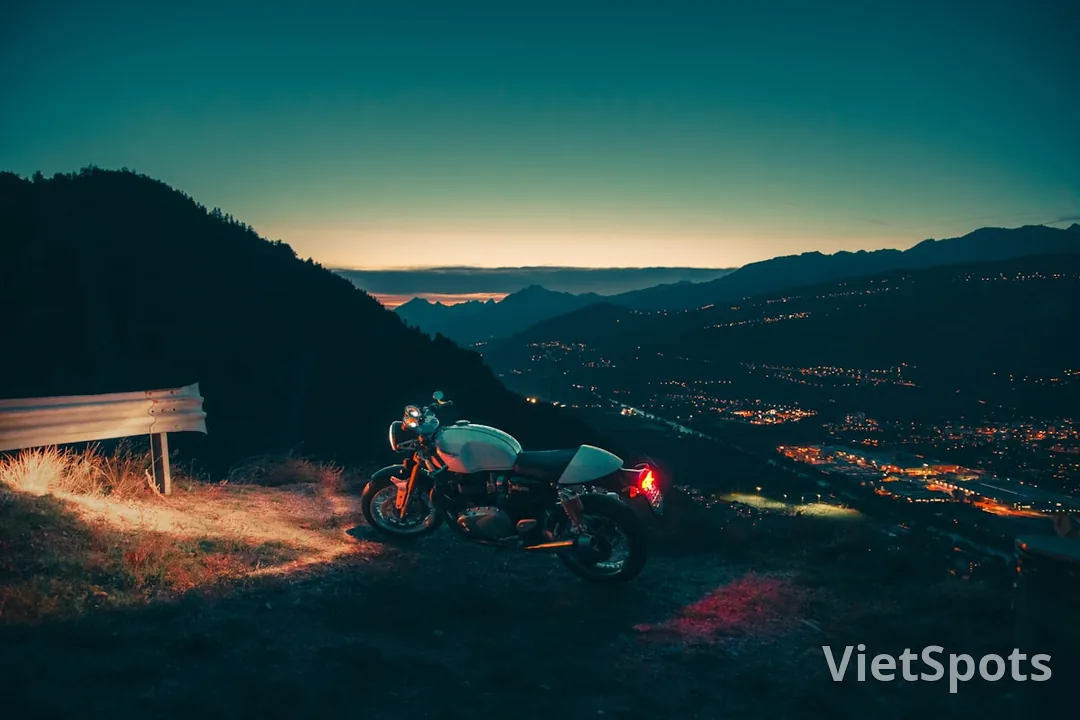 Xe máy đậu trên đỉnh núi với view thành phố ban đêm — phượt scenic