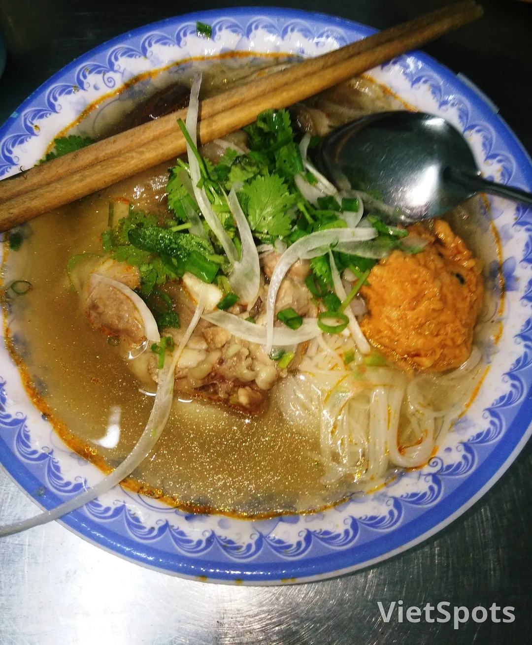 Tô bún bò với chả và ớt sa tế nổi trên mặt