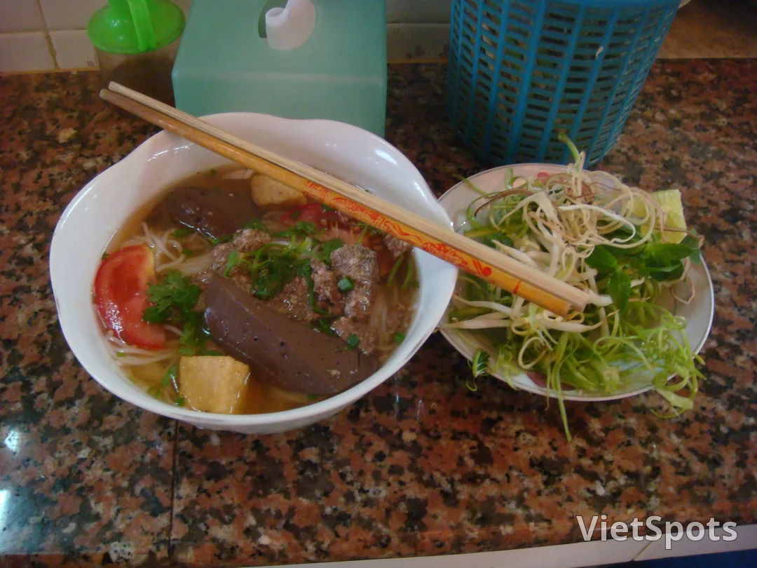 Tô bún riêu cua Việt Nam — tiết heo, tôm chả, cà chua, ngò, bún tươi, đĩa rau sống bên cạnh