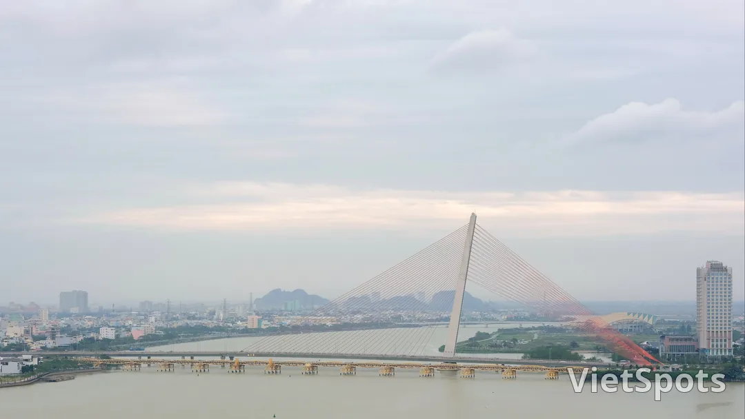 Cầu Trần Thị Lý — tháp A-frame trắng 145m + dây văng hình cánh buồm, sông Hàn + cầu Nguyễn Văn Trỗi vàng bên dưới