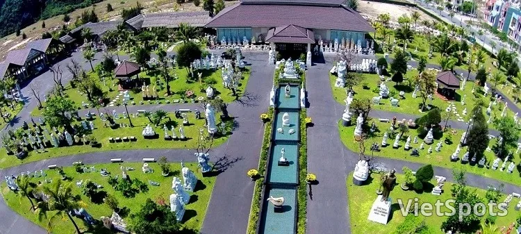 Aerial view làng đá Non Nước Ngũ Hành Sơn — hàng chục tượng đá trắng bày trong sân vườn có đường đi giữa, nhà xưởng, khu bày rộng