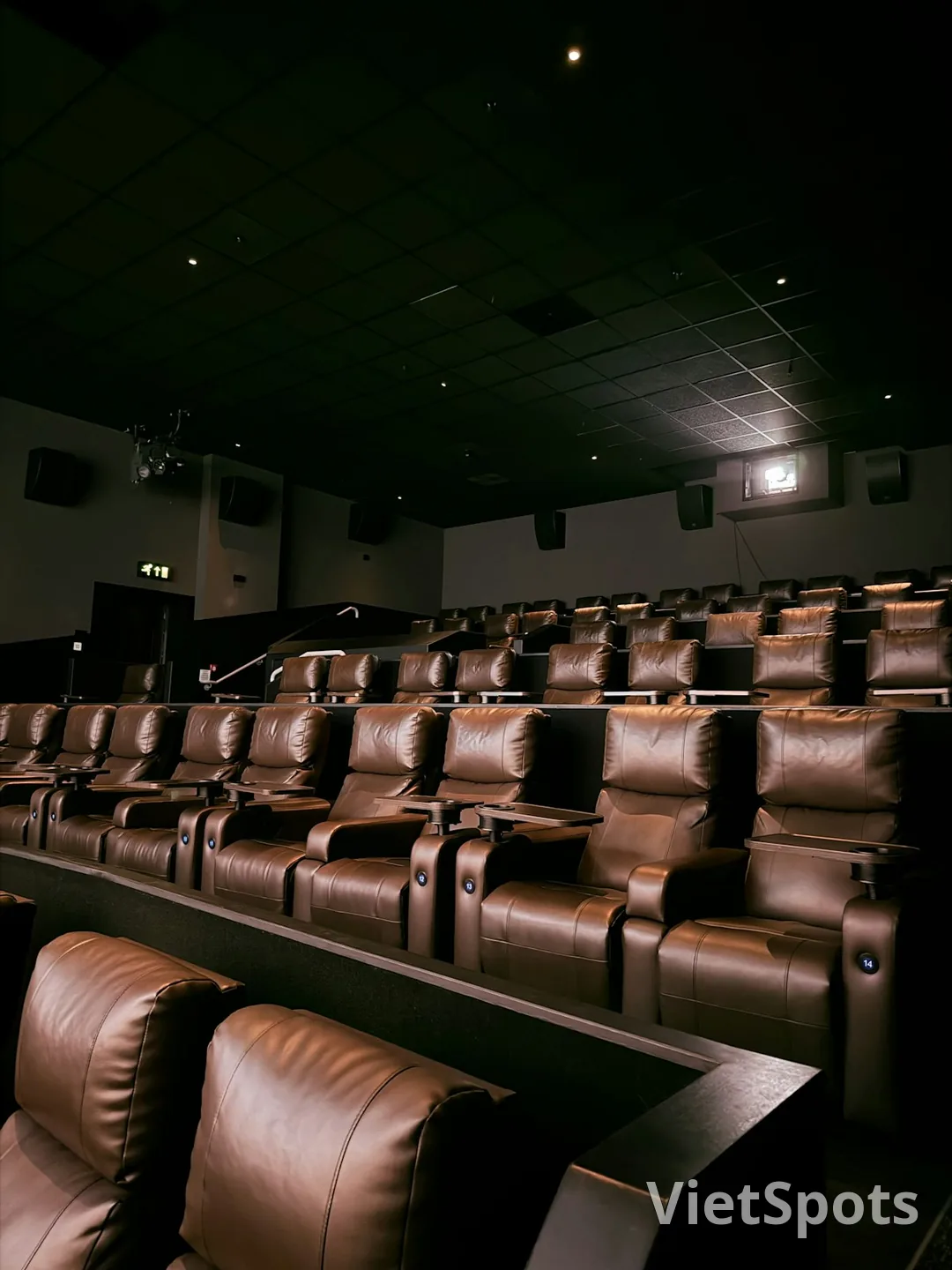 Cinema hiện đại với ghế da nâu cao cấp xếp hàng, projector trên trần