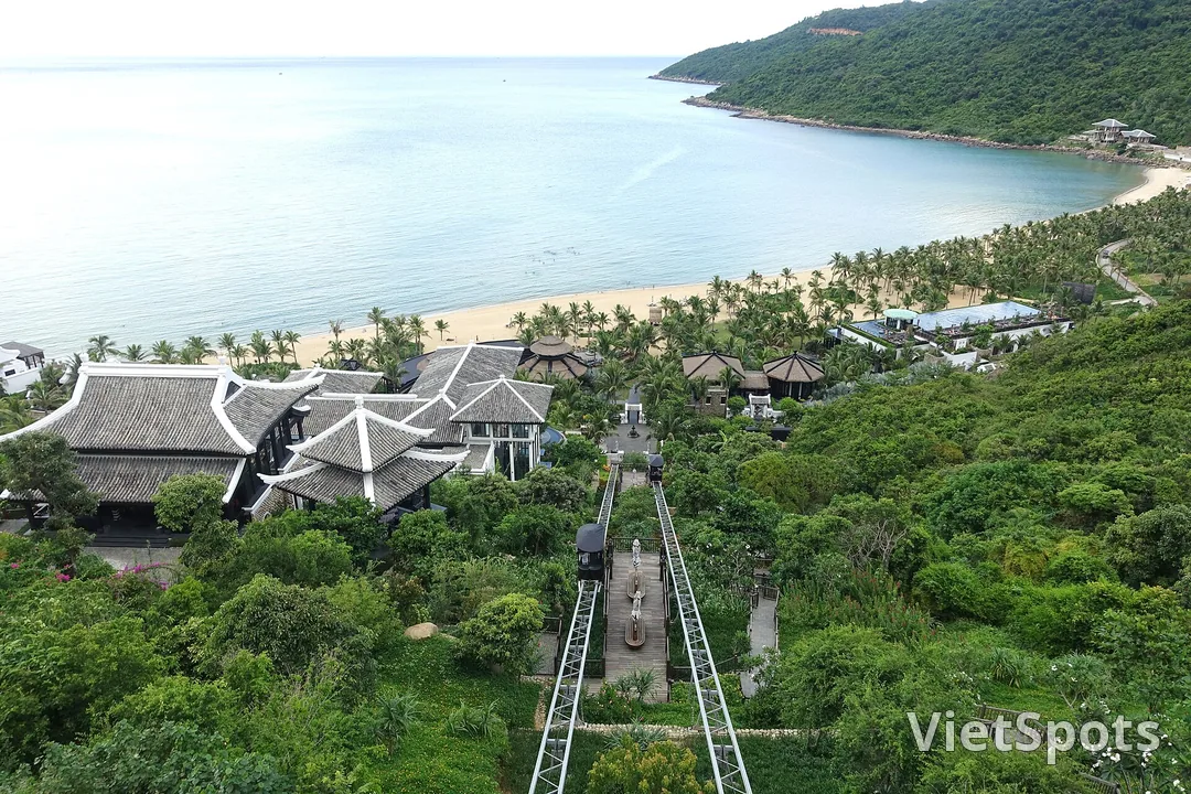Toàn cảnh vịnh Bãi Bắc nhìn từ trên cao, bãi cát cong, hàng dừa và những mái ngói xám của khu nghỉ