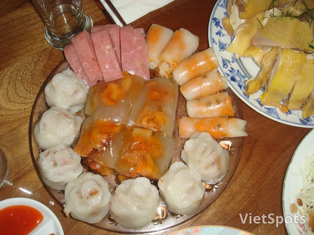 Mâm bánh Huế gồm bánh bèo từng đĩa nhỏ, bánh bột lọc trong suốt, bánh nậm cuốn và chả lát bày quanh