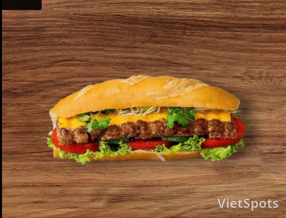 Ổ bánh mì Việt Nam vỏ vàng giòn kẹp thịt, phô mai, cà chua và xà lách, đặt trên mặt gỗ