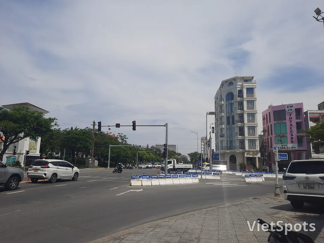 Ngã tư đường Võ Nguyên Giáp ở Đà Nẵng, ô tô và xe máy dừng chờ đèn, dải phân cách sơn mũi tên xanh trắng giữa đường