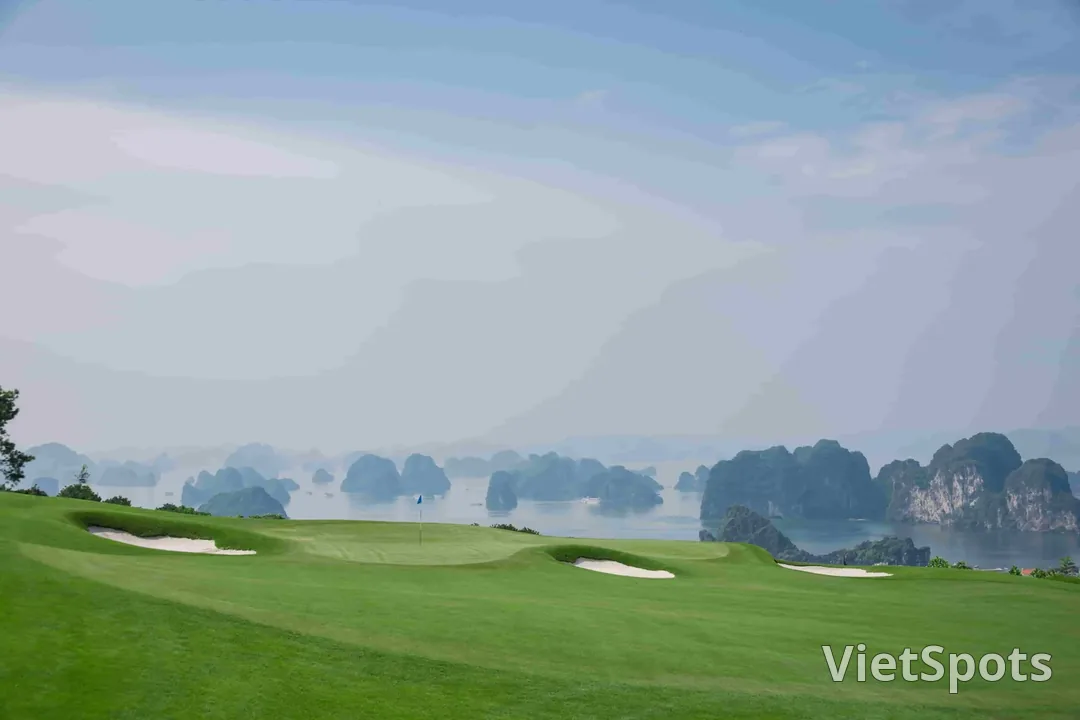 Một green ở sân FLC Hạ Long nhìn thẳng ra những khối núi đá vôi của vịnh Hạ Long trong sương mờ
