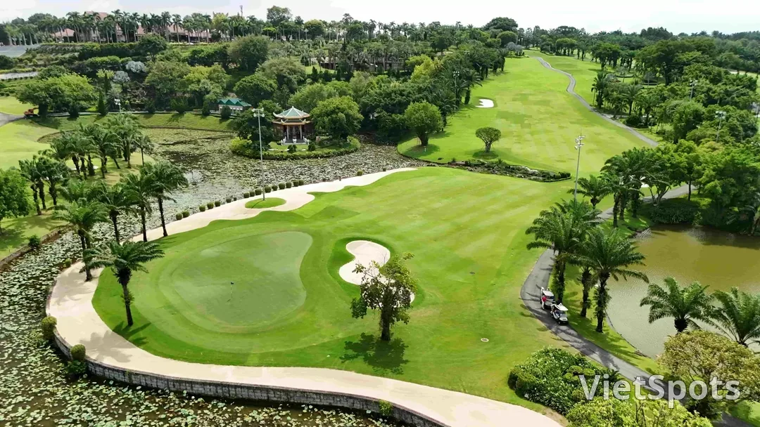 Green ở sân golf Long Thành bao quanh bởi hồ sen và hàng cau, phía xa có một lầu bát giác mái ngói
