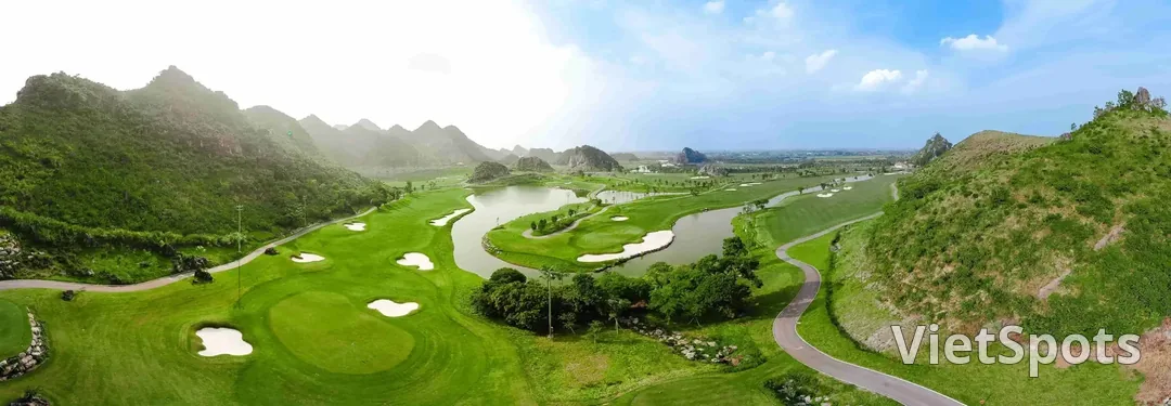 Toàn cảnh sân Legend Valley với hồ nước uốn khúc giữa các fairway, bao quanh là những ngọn núi đá vôi