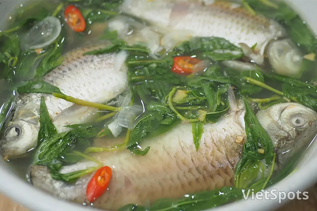 Tô canh cá diếc nấu rau răm, mấy con cá nguyên con nằm trong nước canh trong, rau răm xanh và vài lát ớt đỏ nổi bên trên