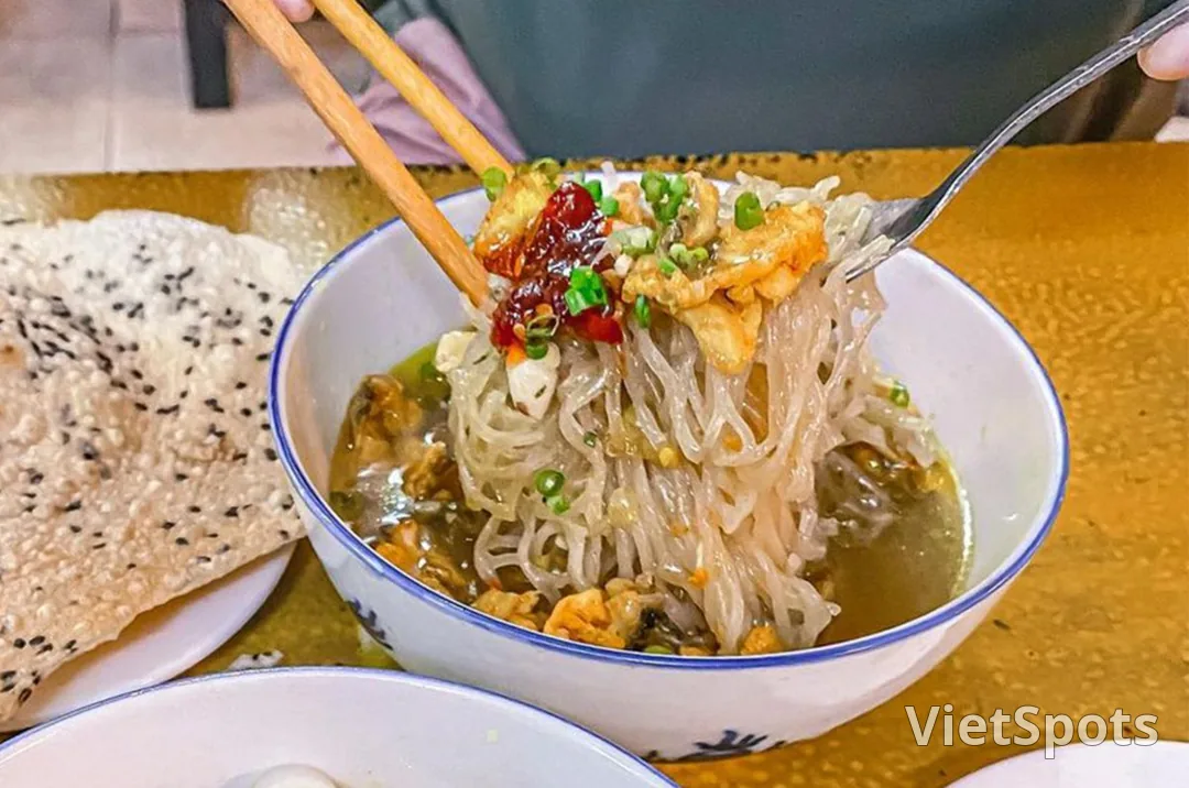 Tô phở sắn nước: sợi phở sắn trắng đục được gắp lên khỏi nước dùng, bên cạnh có bánh tráng mè