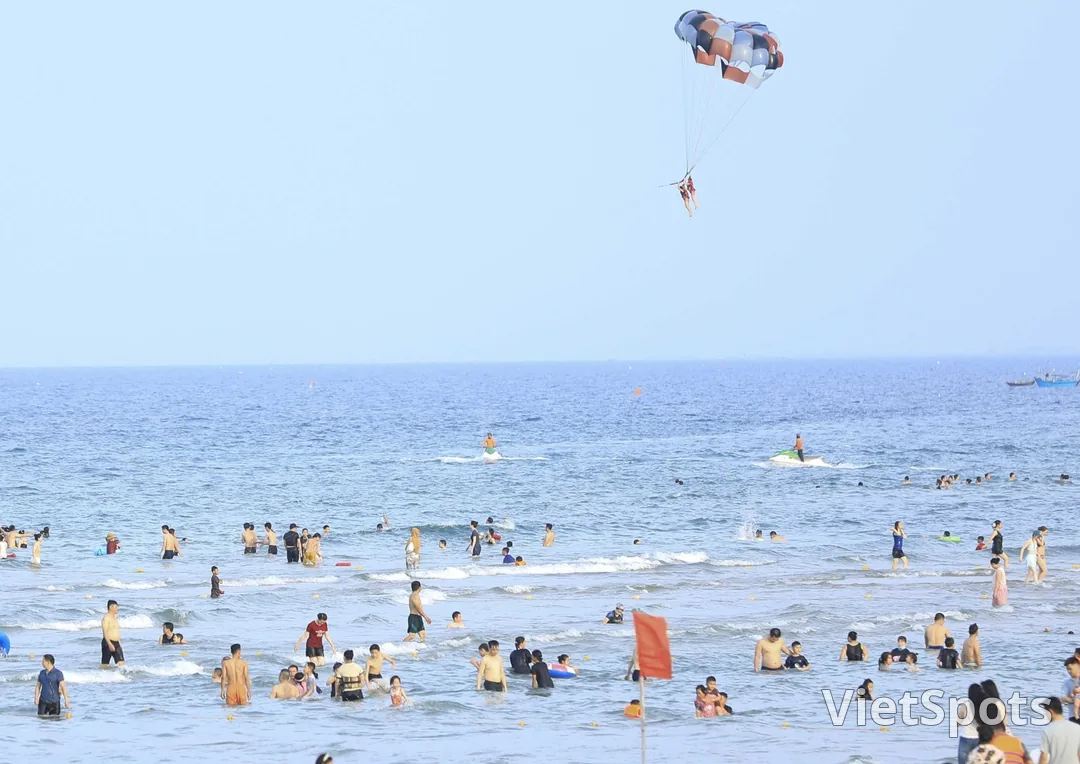 Biển Đà Nẵng mùa hè: dù lượn kéo bằng ca nô bay trên cao, mô tô nước chạy ngoài khơi, người tắm biển đông kín gần bờ