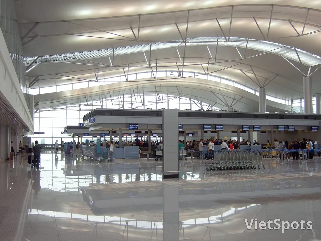 Khu vực check-in sân bay Tân Sơn Nhất với các quầy hãng và bảng điện tử thông tin chuyến bay