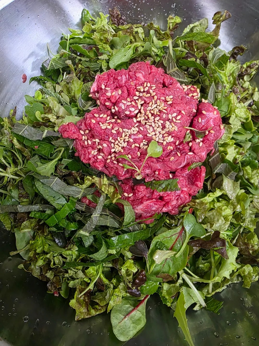 Cơm trộn bibimbap thịt bò sống trong tô đồng