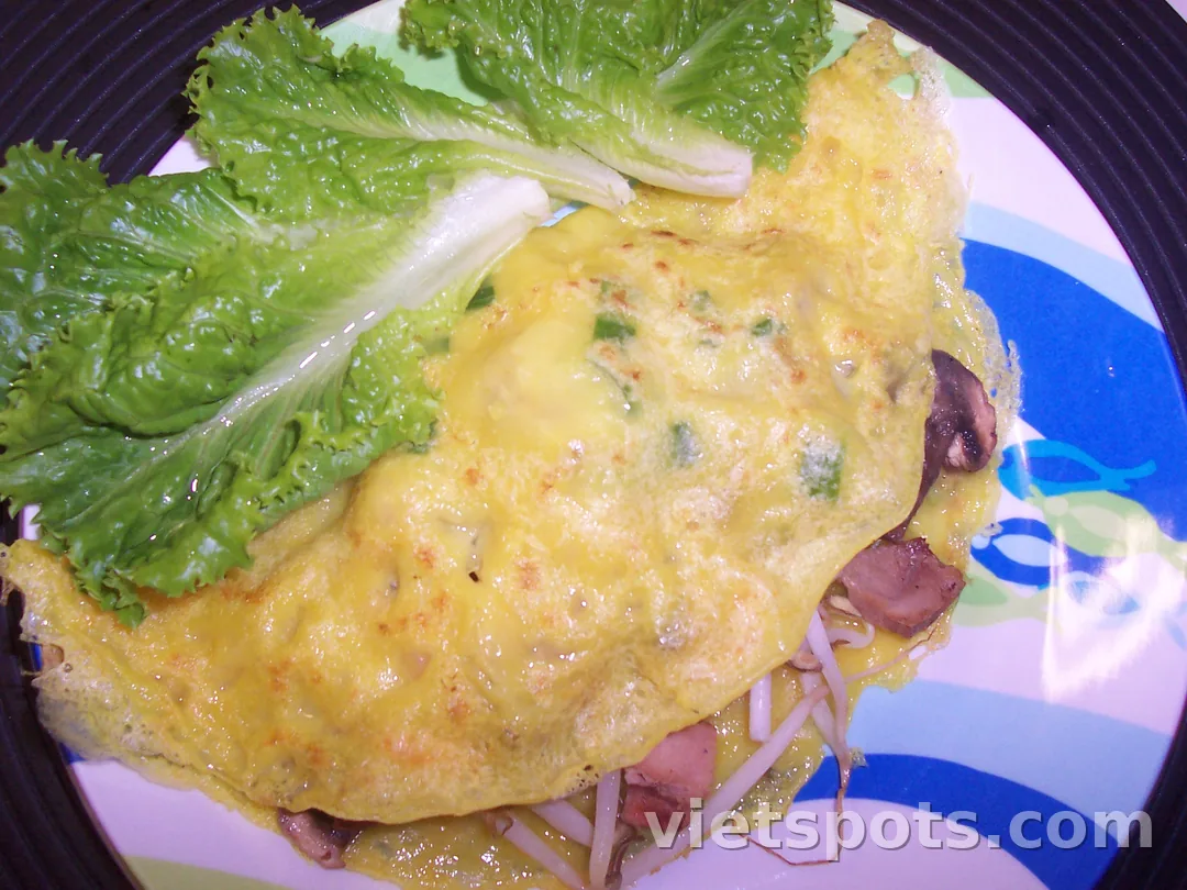 Bánh xèo — vỏ vàng nghệ giòn, nhân giá đỗ và thịt, kèm xà lách