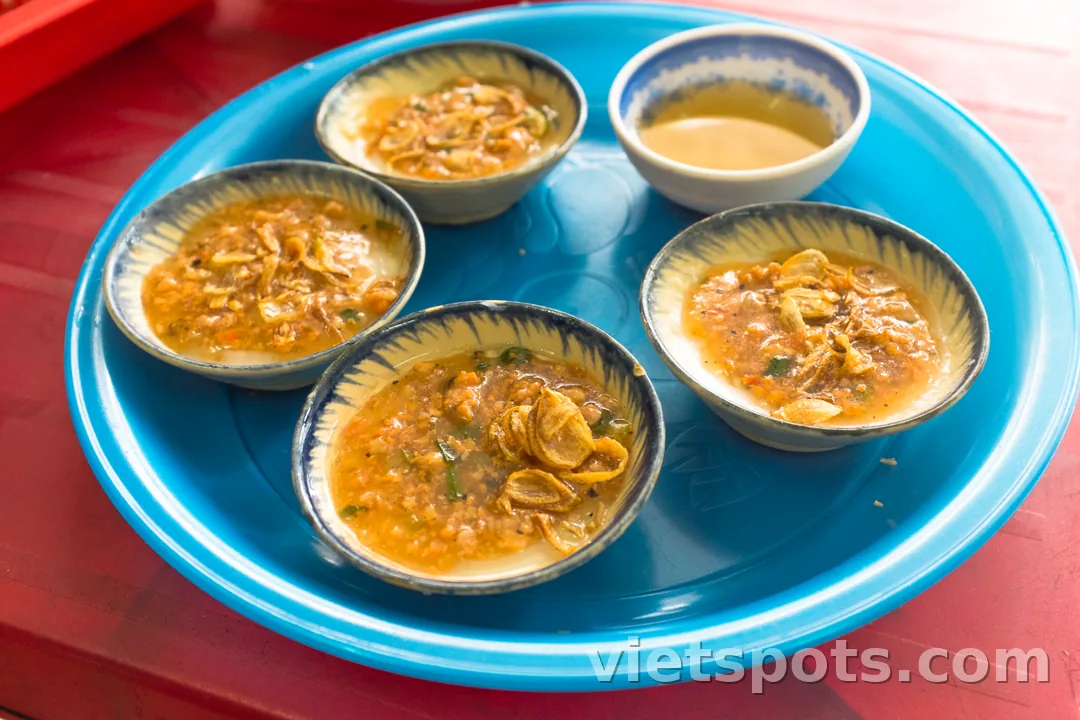 Đĩa xanh với 5 chén bánh bèo — bánh trắng, topping tôm khô + hành phi + nước sốt