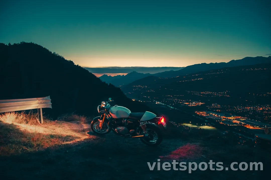 Xe máy đậu trên đỉnh núi với view thành phố ban đêm — phượt scenic