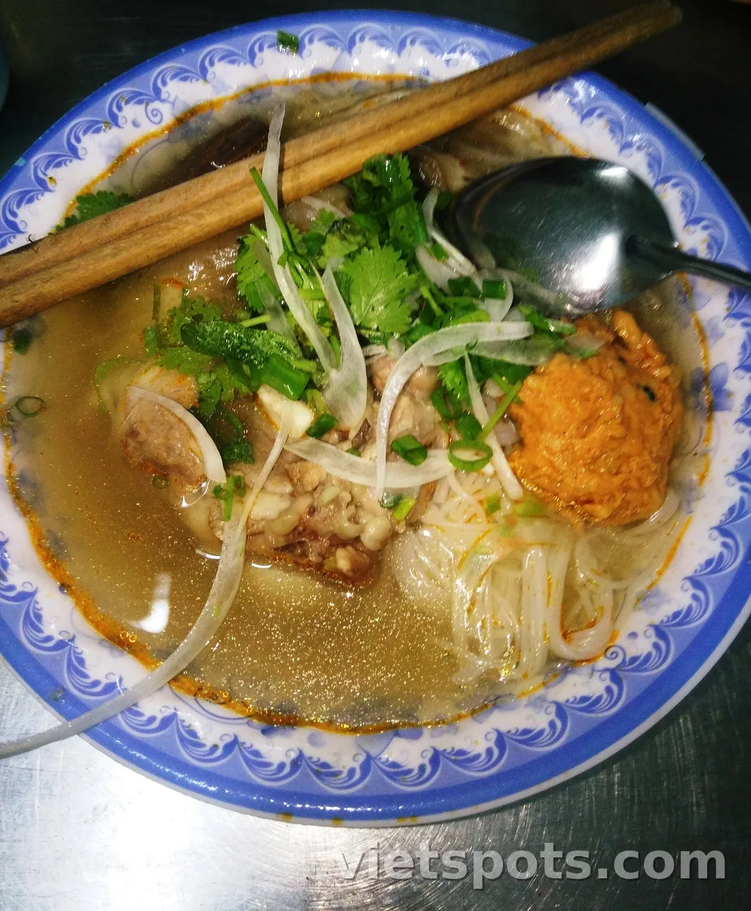 Tô bún bò với chả và ớt sa tế nổi trên mặt