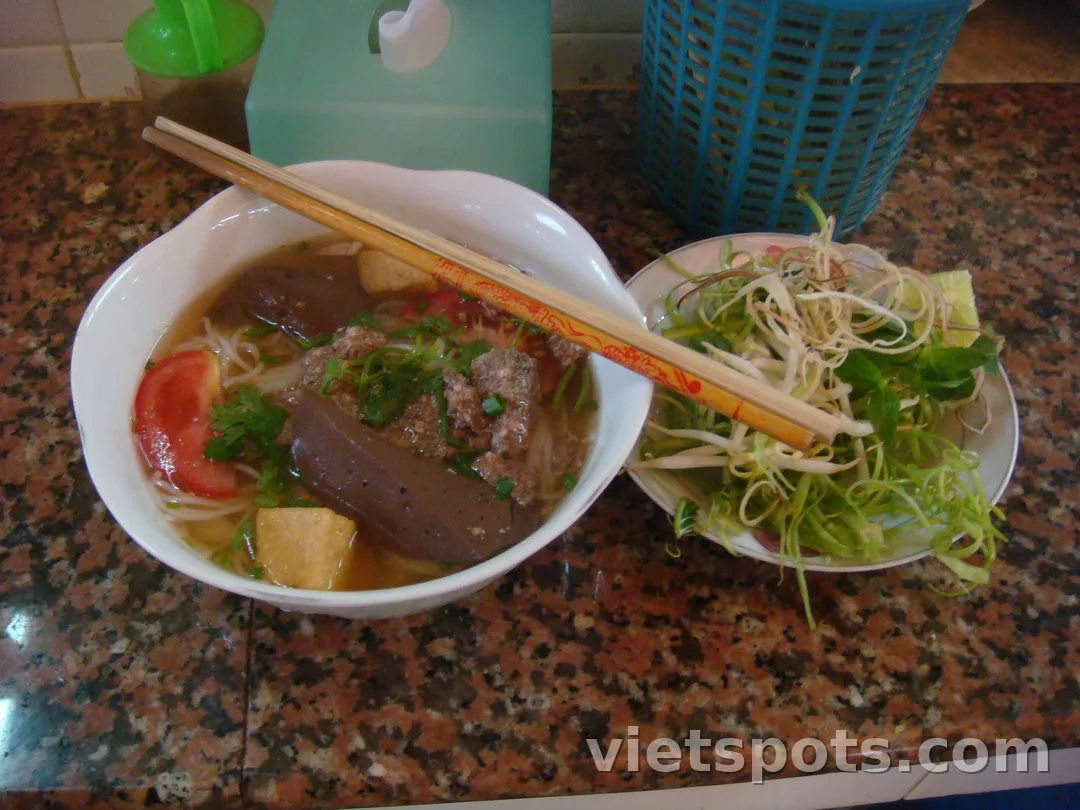Tô bún riêu cua Việt Nam — tiết heo, tôm chả, cà chua, ngò, bún tươi, đĩa rau sống bên cạnh