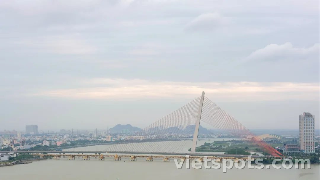 Cầu Trần Thị Lý — tháp A-frame trắng 145m + dây văng hình cánh buồm, sông Hàn + cầu Nguyễn Văn Trỗi vàng bên dưới