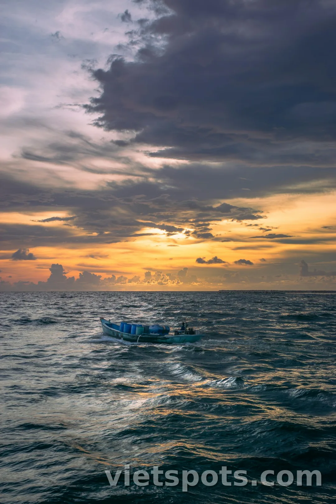 Thuyền cá Việt Nam nhỏ dưới bầu trời hoàng hôn cam tím trên biển — cảnh coastal islet