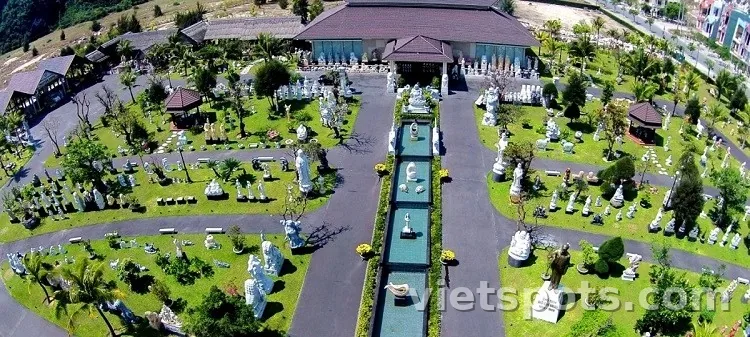 Aerial view làng đá Non Nước Ngũ Hành Sơn — hàng chục tượng đá trắng bày trong sân vườn có đường đi giữa, nhà xưởng, khu bày rộng