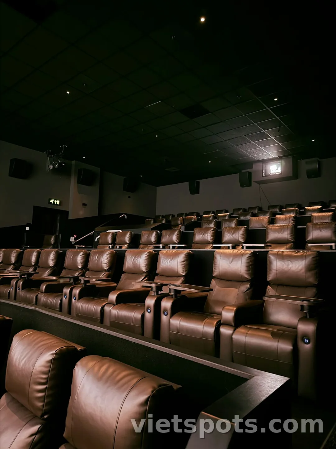 Cinema hiện đại với ghế da nâu cao cấp xếp hàng, projector trên trần